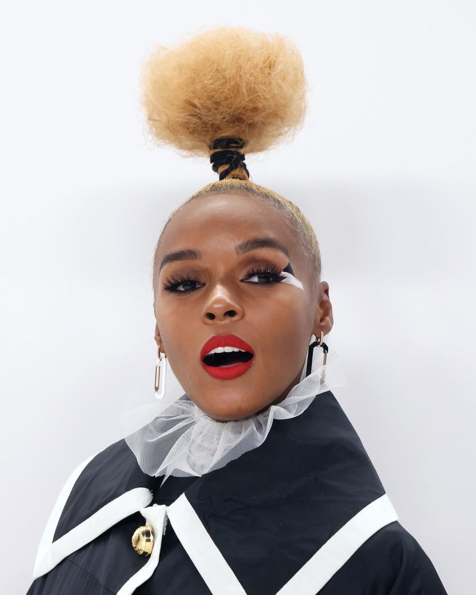 Janelle Monáe at the CFDA Fashion awards in a tall bun, graphic eyeliner, and red lipstick