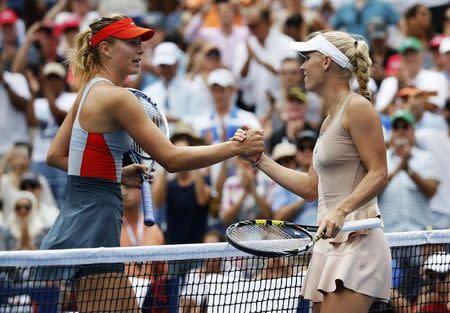 Caroline Wozniacki (R) of Denmark shakes hands with Maria Sharpova of Russia after defeating her at the 2014 U.S. Open tennis tournament in New York, August 31, 2014. REUTERS/Ray Stubblebine