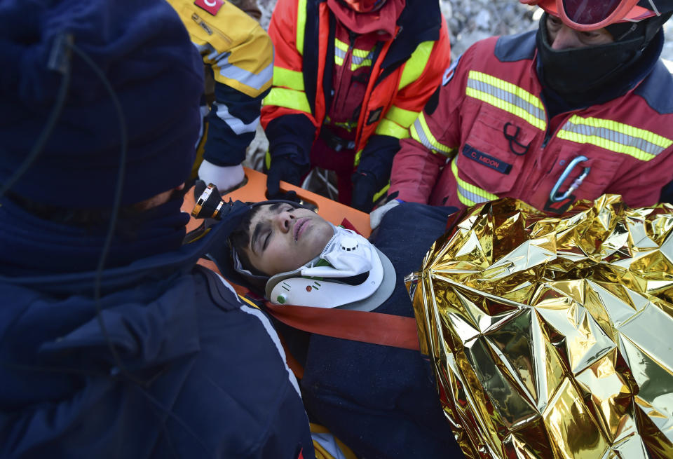 Rescue workers pull out Muhammed Enes Yeninar from the debris of a collapsed building in Kahramanmaras, southern Turkey, Tuesday, Feb. 14, 2023. Rescuers on Tuesday were working to reach people under the rubble in three provinces hit hard by the devastating quakes that hit Turkey and Syria last week. The death toll from the magnitude 7.8 and 7.5 quakes that struck nine hours apart on Feb. 6 in southeastern Turkey and northern Syria passed 35,000, and was certain to increase as search teams find more bodies.(Ismail Coskun/IHA via AP)