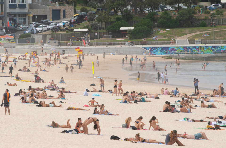 Beachgoers are seen on the sand prior to the closure of Bondi Beach in Sydney. Source: AAP