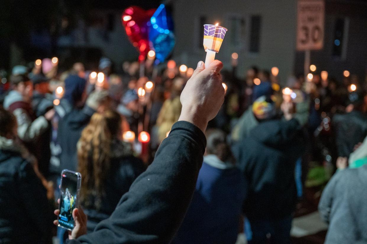 People gather around a memorial at 13th and Spring Street in Mishawaka where Clayton McClish and his girlfriend Elizabeth Johnson were killed Wednesday Dec. 2 when a vehicle being pursued by Mishawaka police crashed into McClish’s car. Wednesday, Dec. 9, 2020, in South Bend.