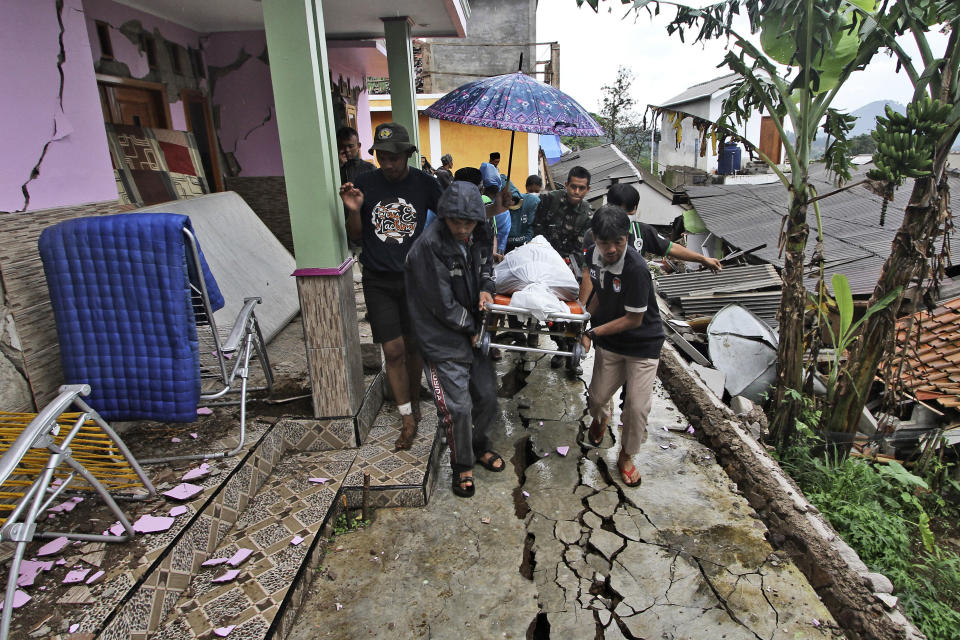 Rescuers and family members carry the body of an earthquake victim on a gurney before a burial in Cianjur, West Java, Indonesia, Wednesday, Nov. 23, 2022. More rescuers and volunteers were deployed Wednesday in devastated areas on Indonesia's main island of Java to search for the dead and missing from an earthquake that killed hundreds of people. (AP Photo)