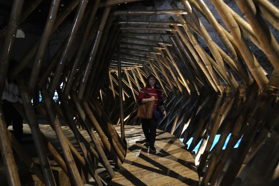 A woman walks inside an installation at the Philippine pavilion, at the Biennale International Architecture exhibition, in Venice, Italy, Wednesday, May 17, 2023. The 18th edition of the Biennale International Architecture exhibition will open to the public from Saturday May 20 to Sunday Nov. 26, 2023. (AP Photo/Antonio Calanni)