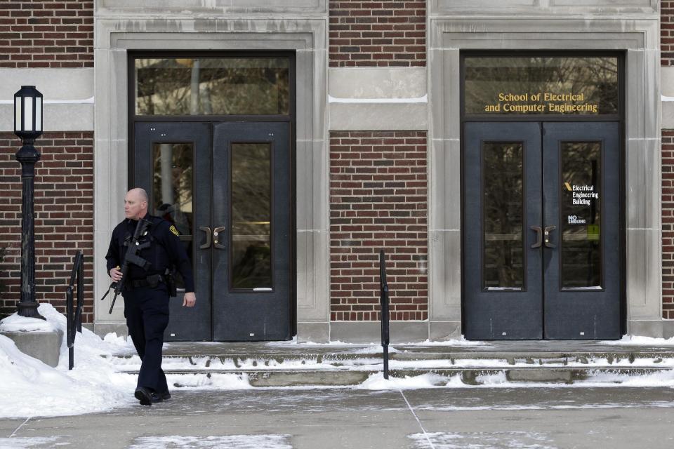 A police officer walks out of the Electrical Engineering Building on the campus of Purdue University in West Lafayette, Ind., Tuesday, Jan. 21, 2014 where one person was killed inside a classroom by a gunman who surrendered to a police officer within minutes of the attack, officials said.. (AP Photo/Michael Conroy)