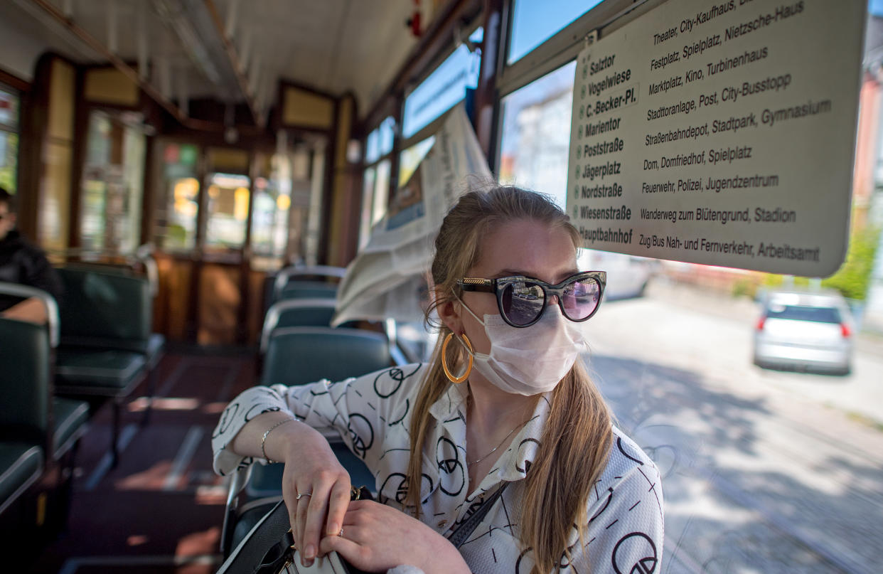 21 April 2020, Saxony-Anhalt, Naumburg: Josephine Nauke sits in the historic tram in Naumburg with a face mask. The railcar type "Gotha" was built in 1959 and runs regularly on line four between Salztor and the main station. Even in the smallest tram operation in Germany, passengers will be required to wear masks from Thursday (23.04.2020). The federal state of Saxony-Anhalt had decided to make it compulsory to wear a face mask on buses and trains and when shopping on Tuesday. Photo: Hendrik Schmidt/dpa-Zentralbild/dpa (Photo by Hendrik Schmidt/picture alliance via Getty Images)