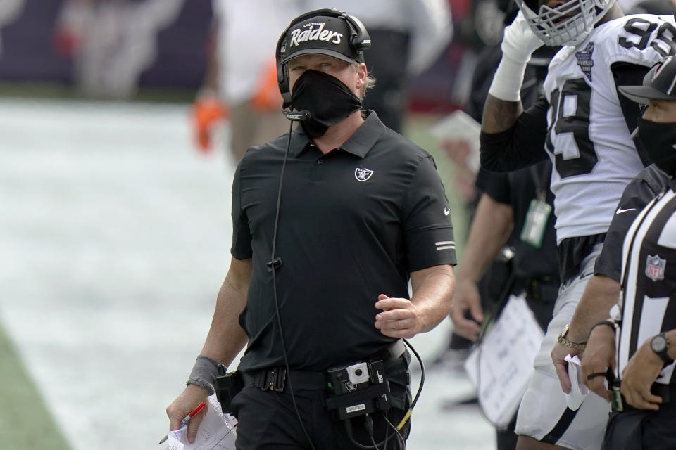 Jon Gruden works along the sideline in the second half wearing a mask that still covers his nose and mouth but no longer covers his neck as it did earlier in the day.