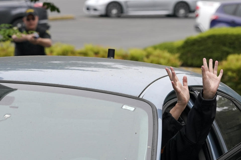 An instructor playing the role of a suspect in a vehicle sticks her hands out of a car door during a training class at the Washington state Criminal Justice Training Commission, Wednesday, July 14, 2021, in Burien, Wash. Washington state is embarking on a massive experiment in police reform and accountability following the racial justice protests that erupted after George Floyd's murder last year, with nearly a dozen new laws that took effect Sunday, July 25, but law enforcement officials remain uncertain about what they require in how officers might respond — or not respond — to certain situations, including active crime scenes and mental health crises. (AP Photo/Ted S. Warren)