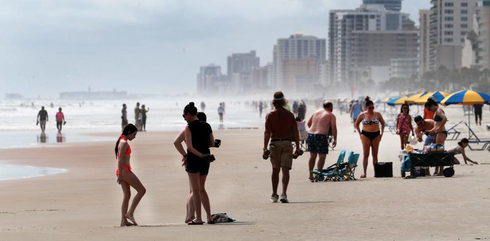 Beachgoers gather along the sand near Sun Splash Park in Daytona Beach. This weekend's weather forecast calls for the typical mix of sun and showers in Daytona Beach, despite potential tropical storm activity in the Gulf of Mexico.