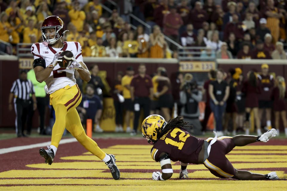 Southern California wide receiver Duce Robinson scores a touchdown while Minnesota defensive back Darius Green (12) falls to the field during the first half of an NCAA college football game, Saturday, Oct. 5, 2024, in Minneapolis. (AP Photo/Ellen Schmidt)