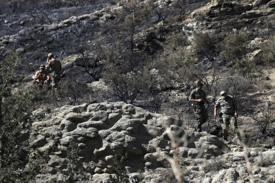 Turkish soldiers patrol the area after an explosion pre-dawn, outside of village of Tashkent in Turkish Cypriot breakaway north part of the divided Cyprus, Monday, July 1, 2019. A Turkish Cypriot official said Monday that a Syrian anti-aircraft missile that missed its target and reached ethnically divided Cyprus may have been the cause of an explosion outside a village in east Mediterranean island notion's breakaway north. No injuries were reported. (AP Photo/Petros Karadjias)