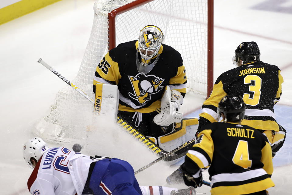 Pittsburgh Penguins goaltender Tristan Jarry (35) stops a shot by Montreal Canadiens' Artturi Lehkonen (62) with Justin Schultz (4) and Jack Johnson (3) defending during the first period of an NHL hockey game against the Montreal Canadiens in Pittsburgh, Tuesday, Dec. 10, 2019. (AP Photo/Gene J. Puskar)