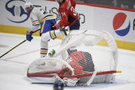 The net falls onto Washington Capitals goaltender Vitek Vanecek (41) during the first period of an NHL hockey game as Buffalo Sabres right wing Kyle Okposo (21) looks on Sunday, Jan. 24, 2021, in Washington. (AP Photo/Nick Wass)