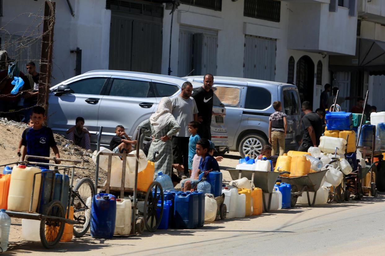 <span>Palestinians wait to fill their bottles with clean water in Deir al-Balah, Gaza, on 15 August 2024.</span><span>Photograph: Abed Rahim Khatib/Anadolu via Getty Images</span>