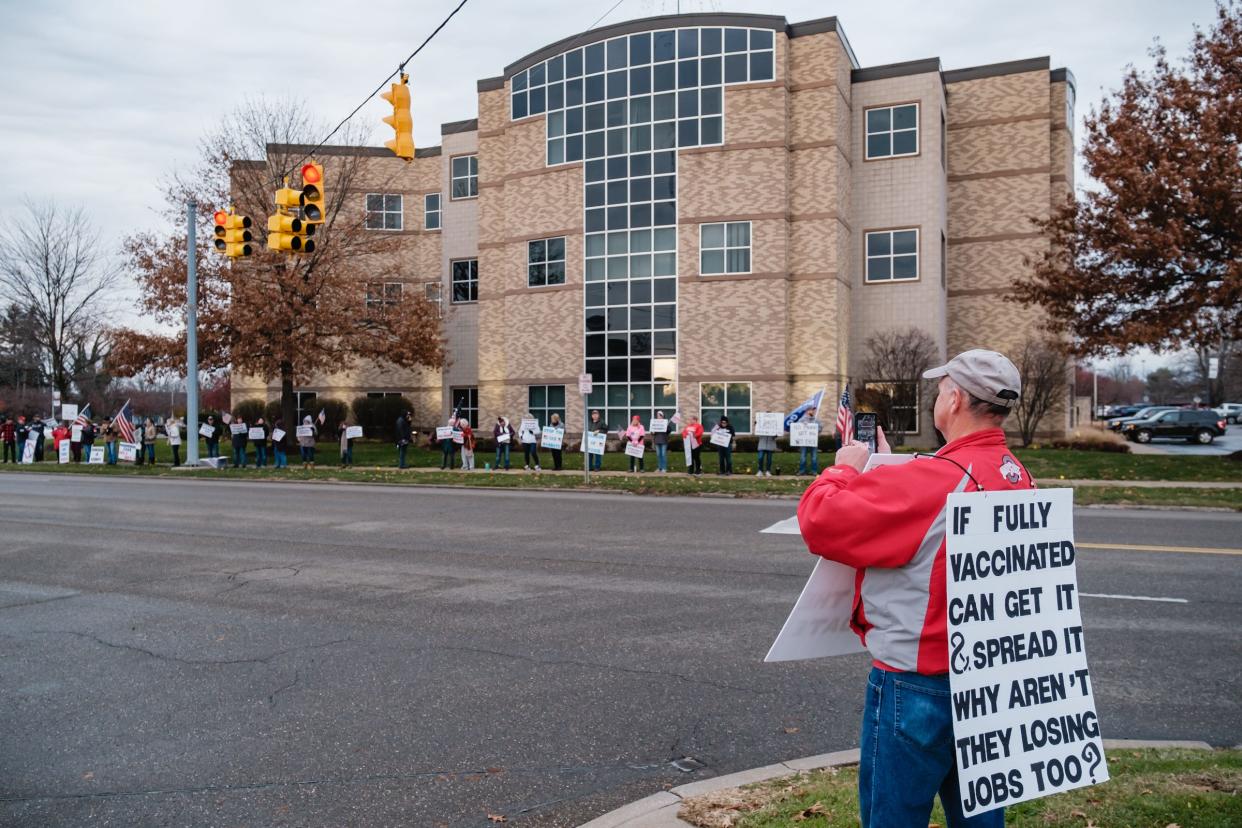 A man photographs fellow protestors during Friday's “Stop the Mandate” protest in front of Cleveland Clinic Union Hospital in Dover. He said his wife works at the hospital, and that "she has already been harassed." He did not want to be identified by name. The protesters were objecting to a federal mandate requiring health care workers to be vaccinated against COVID-19. A judge has halted implementation of the rule. ANDREW DOLPH/TIMES-REPORTER