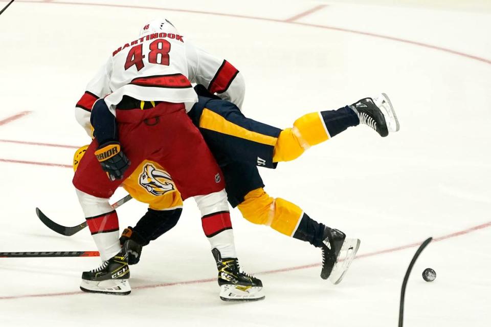 Carolina Hurricanes left wing Jordan Martinook (48) collides with Nashville Predators center Mikael Granlund (64) in the third period of an NHL hockey game Saturday, Oct. 16, 2021, in Nashville, Tenn. (AP Photo/Mark Humphrey)