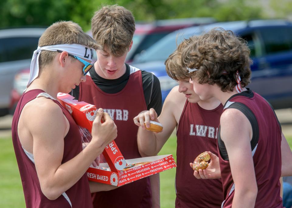 Wyatt Isaacson, far left, shares his doughnuts with his LWRB teammates after taking a victory in the Throwers 60-meter dash, a race between the top four shot put throwers, during the first annual Cinder Classic track and field meet Saturday, May 4, 2024 in Roanoke. The reward for the unofficial race was a couple boxes of doughnuts.