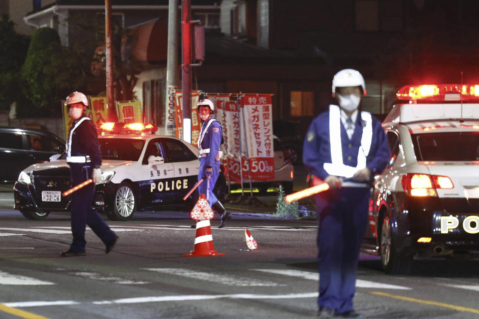 Police officers stand guard on a street near a building where a man is holed up in Nakano, central Japan, Thursday, May 25, 2023. Multiple people including a few police officers were killed in Nakano, a city in Nagano prefecture, in central Japan on Thursday and a suspect with a rifle and knife was holed up inside a house, police said. (Takuto Kaneko/Kyodo News via AP)