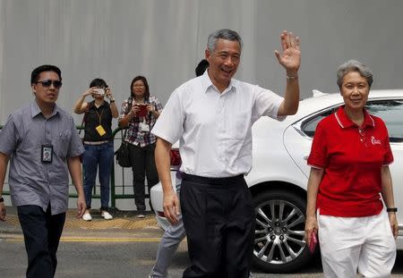 Singapore's Prime Minister and Secretary-General of the People's Action Party Lee Hsien Loong (2nd R) and his wife Ho Ching (R) arrive to cast their votes at a polling center in Singapore September 11, 2015. REUTERS/Edgar Su