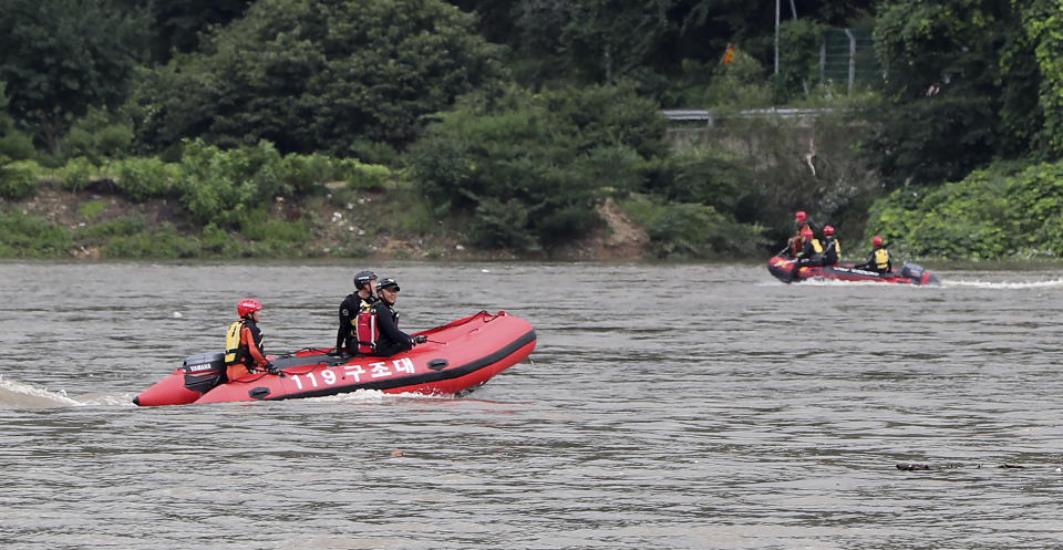 Rescue workers use boats to search for missing people in floodwaters in Gapyoeng, South Korea, Thursday, Aug. 6, 2020. Torrential rains continuously pounded South Korea on Thursday, prompting authorities to close parts of highways and issue a rare flood alert near a key river bridge in Seoul. (Yang Ji-ung/Yonhap via AP)