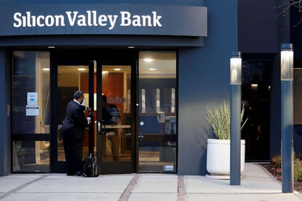 PHOTO: FILE - A bank employee waits to be let in outside of the Silicon Valley Bank headquarters in Santa Clara, Calif., March 13, 2023. (Brittany Hosea-Small/Reuters, FILE)