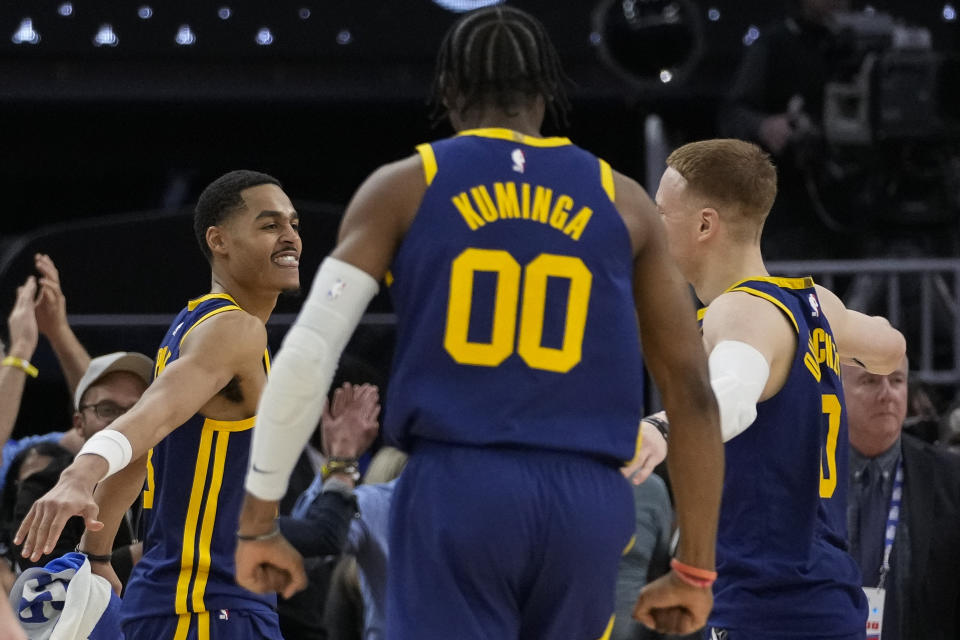 Golden State Warriors guard Jordan Poole, left, celebrates with Donte DiVincenzo, right, after scoring the game-winning basket against the Memphis Grizzlies during the second half of an NBA basketball game in San Francisco, Wednesday, Jan. 25, 2023. (AP Photo/Godofredo A. Vásquez)