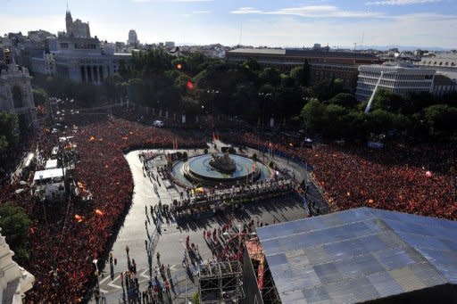 People wait to watch the Spanish national football team parade in Madrid, a day after it won the final match of the Euro 2012 championships 4-0 against Italy in Kiev