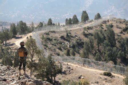 A soldier stands guard along the border fence at the Angoor Adda outpost on the border with Afghanistan in South Waziristan, Pakistan October 18, 2017. REUTERS/Caren Firouz