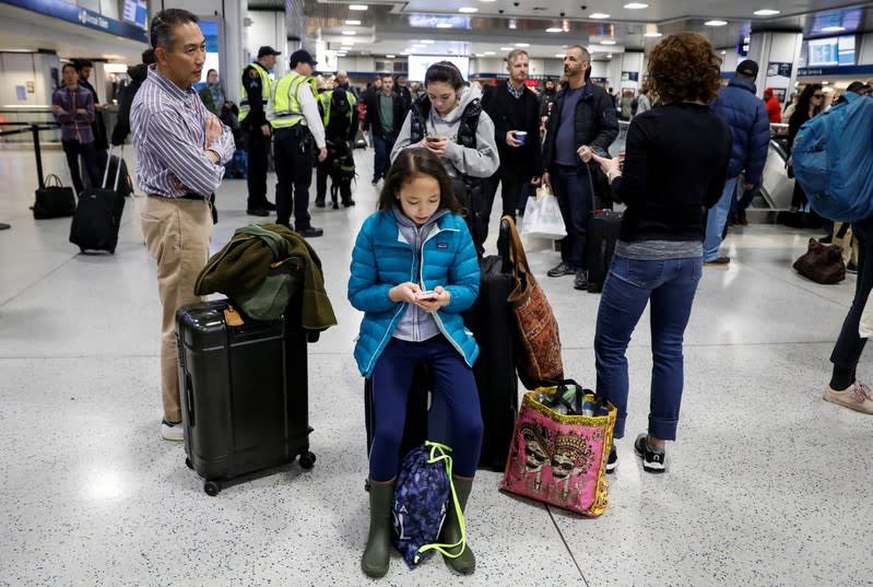 Travelers wait in the boarding area for trains during the Thanksgiving holiday travel rush at Pennsylvania Station in New York