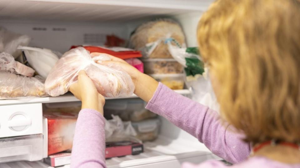 Persona refrigerando alimentos