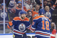 Edmonton Oilers' Leon Draisaitl (29) and Zach Hyman (18) celebrate a goal during the second period of Game 3 of an NHL hockey Stanley Cup second-round playoff series against the Vancouver Canucks in Edmonton, Alberta, Sunday, May 12, 2024. (Jason Franson/The Canadian Press via AP)