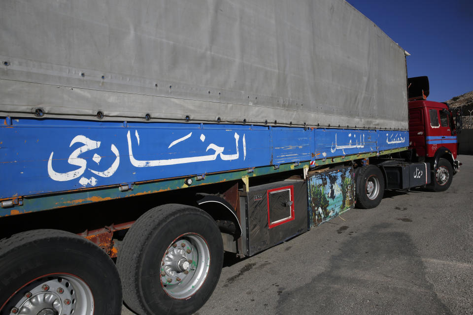 In this Wednesday, Oct. 31, 2018 photo, a truck with Arabic that reads, "Dedicated for external transport," crosses the Lebanese border crossing point of al-Masnaa to Syria, in the Bekaa Valley, Lebanon. The long-awaited reopening of a vital border crossing between Syria and Jordan earlier this month was supposed to bring relief to Lebanese farmers and traders looking to resume exports to Gulf countries. But the commerce has so far been complicated by politics, high transit fees and fighting over which trucks pass through which country. (AP Photo/Hussein Malla)