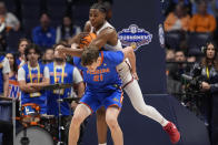Alabama forward Nick Pringle (23) fouls Florida forward Alex Condon (21) as he comes down with a rebound during the first half of an NCAA college basketball game at the Southeastern Conference tournament Friday, March 15, 2024, in Nashville, Tenn. (AP Photo/John Bazemore)