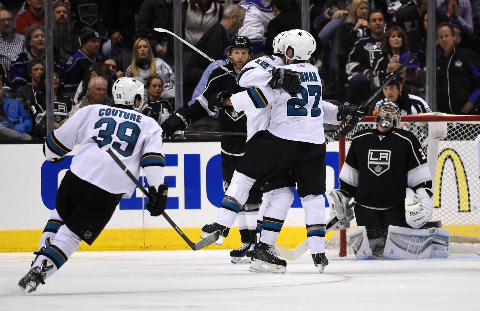 San Jose Sharks center Patrick Marleau, center, celebrates his game-winning goal with defenseman Scott Hannan, second from right, as Los Angeles Kings goalie Jonathan Quick, right, looks on and center Logan Couture skates in during the overtime period in Game 3 of an NHL hockey first-round playoff series, Tuesday, April 22, 2014, in Los Angeles. The Sharks won 4-3. (AP Photo/Mark J. Terrill)