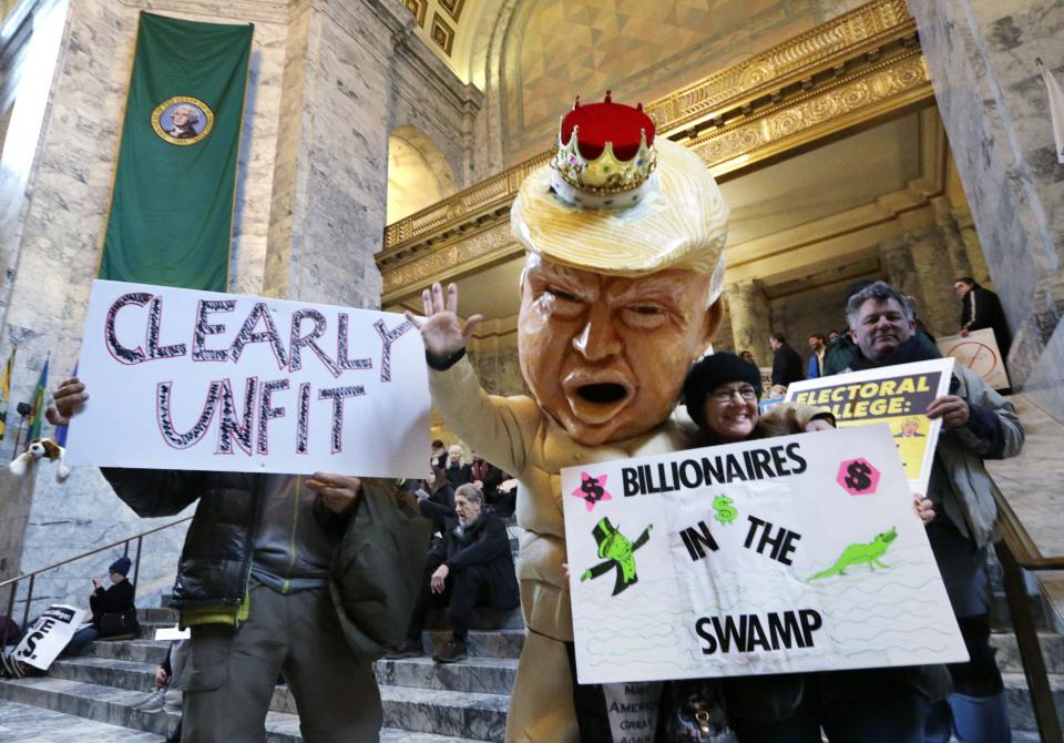 Jo Walter, of Bremerton, Wash., wears a large Donald Trump head mock-up as she protests Electoral College voting Monday, Dec. 19, 2016, in Olympia, Wash. (Photo: Elaine Thompson/AP)