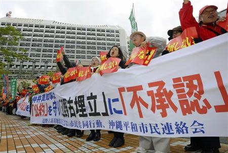 Protesters shout slogans during a rally against the relocation of a U.S. military base, in front of the Okinawa prefectural government office building, in Naha on the Japanese southern islands of Okinawa, in this photo taken by Kyodo December 27, 2013. REUTERS/Kyodo