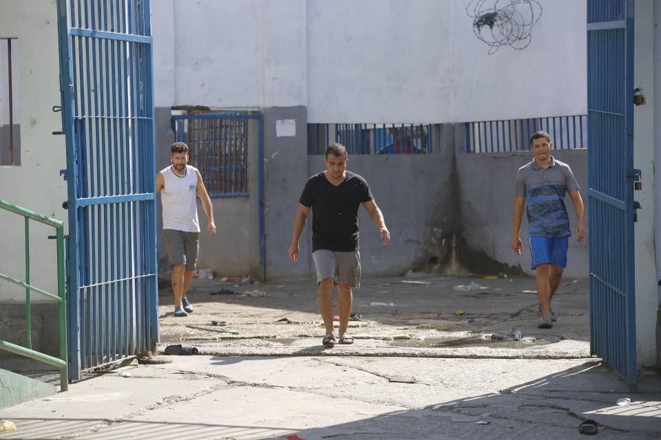 Colombian inmates accused of participating in the assassination of Haitian President Jovenel Moise walk inside the National Penitentiary in Port-au-Prince, Haiti, Sunday, March 3, 2024. Hundreds of inmates have fled Haiti's main prison after armed gangs stormed the facility overnight. (AP Photo/Odelyn Joseph)