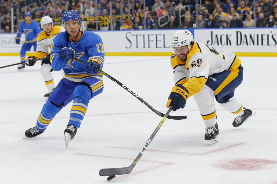 Nashville Predators' Roman Josi, right, of Switzerland, reaches for the puck as he is pressured by St. Louis Blues' Jaden Schwartz during the second period of an NHL hockey game Saturday, Feb. 15, 2020, in St. Louis. (AP Photo/Billy Hurst)