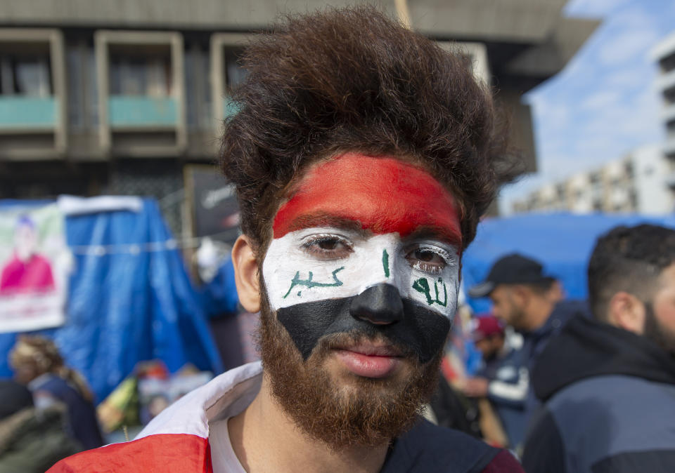 An anti government protester colors his face with the Iraqi flag, during the ongoing protests in Tahrir square, Baghdad, Iraq, Friday, Jan. 10, 2020. (AP Photo/Nasser Nasser)