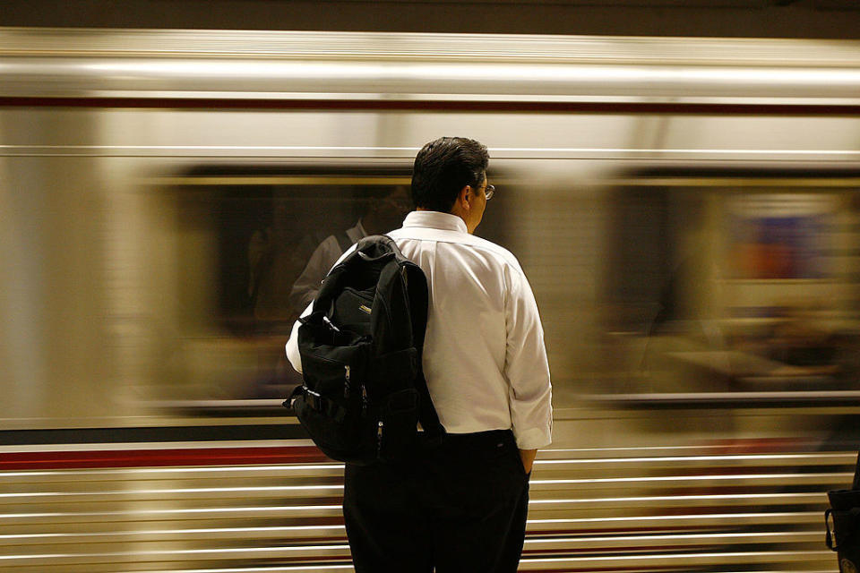 A passenger waits for the Metro train to stop in Los Angeles, CA