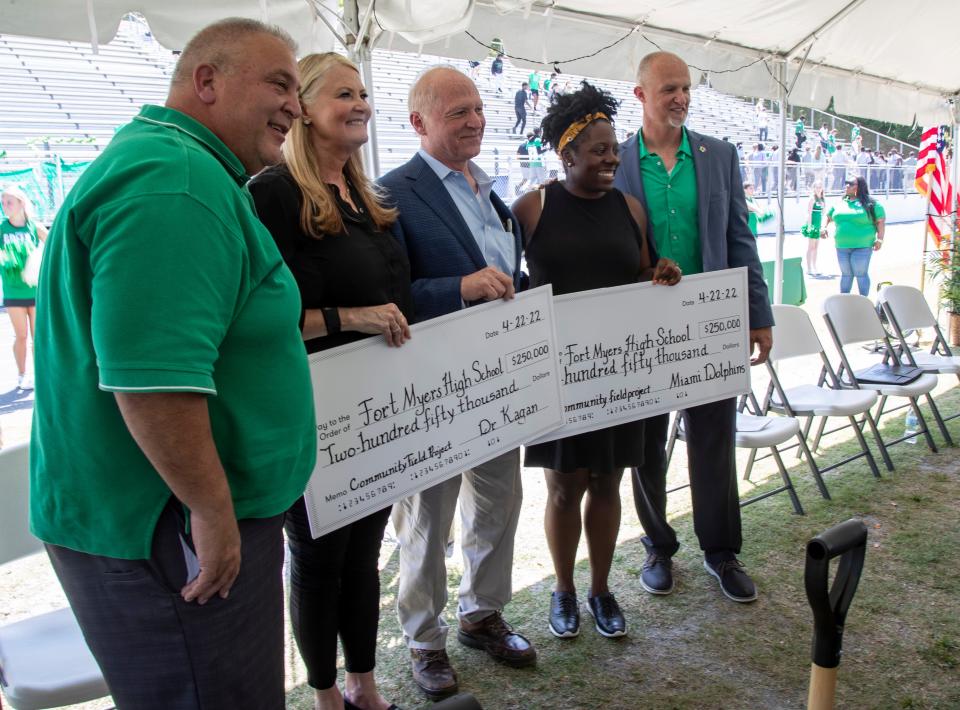 Sam Sirianni Jr., Liz and John Kagan, RaShauna Hamilton, and Robert Butz display two checks for $250,000 each at the groundbreaking for the new turf field and rubber track at Fort Myers High School on Friday, April 22, 2022. 