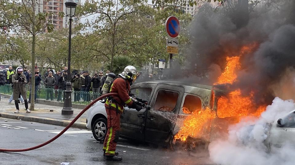 Ein Feuerwehrmann löscht in Paris ein von «Gelbwesten» in Brand gesetztes Auto.