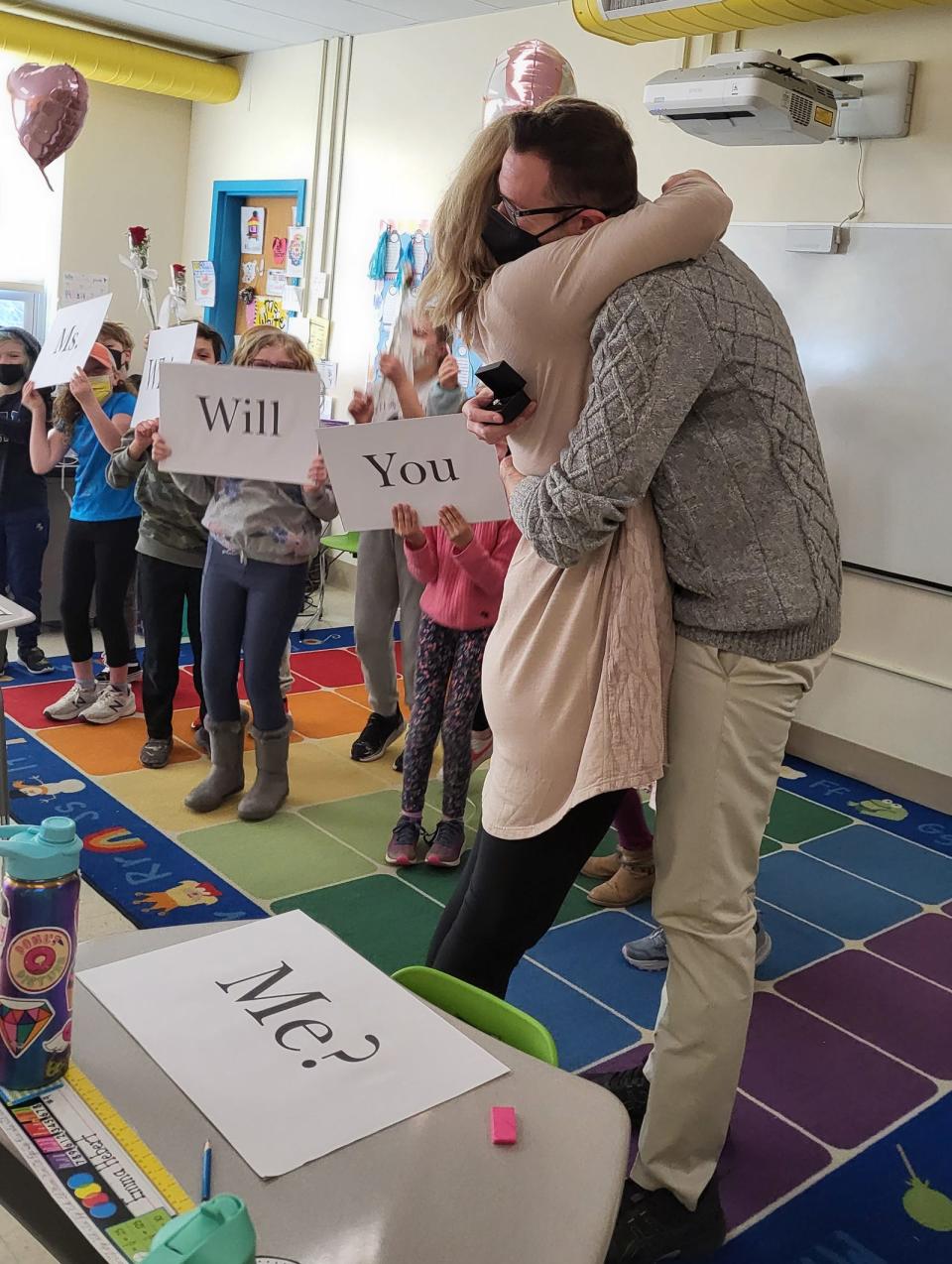 Third-grade teacher Nicole White embraces husband-to-be Nick Driscoll after his proposal to her in class at Dover's Garrison Elementary School Friday, Feb. 18, 2022.