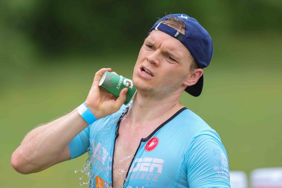 A competitor pours water on himself to cool off during the Bear Triathlon on May 15 at Lums Pond State Park.