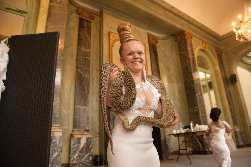 A model poses with a snake before heading for the runway. (Photo: Getty Images)