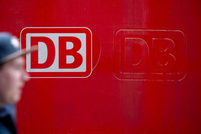 Aperson passes by the Deutsche Bahn (DB) logo stuck on one of the trains, during a strike by the German Train Drivers' Union (GDL). The GDL has called for a further 24-hour strike in both passenger and freight transport. Peter Kneffel/dpa