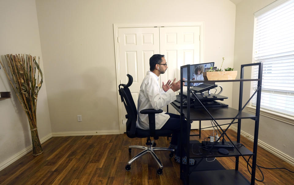 Medical director of Doctor on Demand Dr. Vibin Roy speaks to a patient during an online primary care visit conducted from his home, Friday, April 23, 2021, in Keller, Texas. Some U.S. employers and insurers want you to make telemedicine your first choice for most doctor visits. Retail giant Amazon and several insurers have started or expanded virtual-first care plans to get people thinking telemedicine routinely, even for annual checkups. (AP Photo/LM Otero)