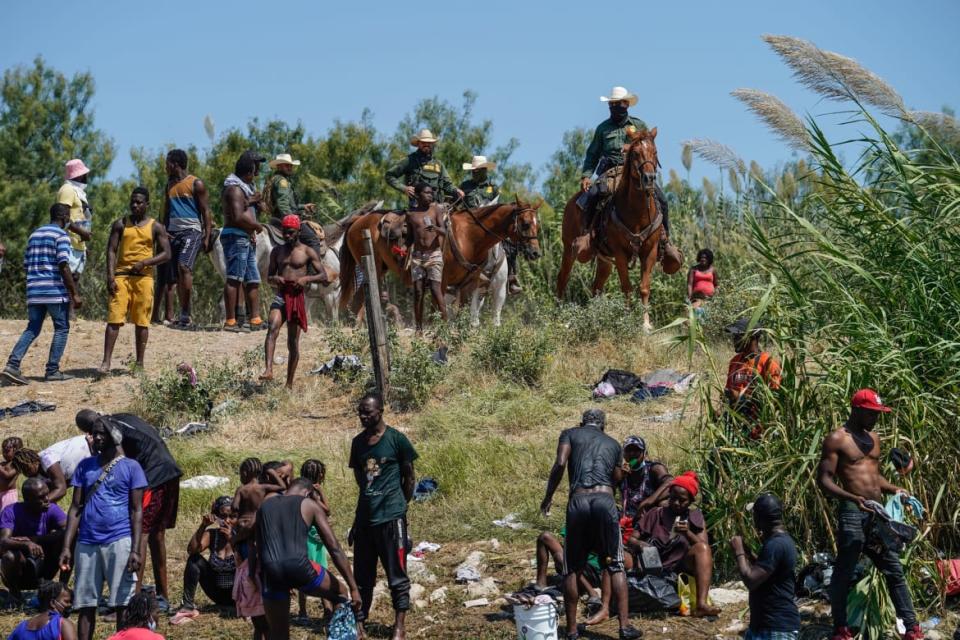 <div class="inline-image__title">1235368965</div> <div class="inline-image__caption"><p>United States Border Patrol agents on horseback look on as Haitian migrants sit on the river bank near an encampment on the banks of the Rio Grande near the Acuna Del Rio International Bridge in Del Rio, Texas on September 19, 2021</p></div> <div class="inline-image__credit">AFP via Getty</div>