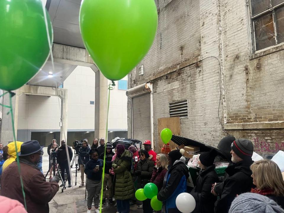 Gatherers listen as members of the community give remarks on the tragic death of Grayson, in the alley of Grand Loft Apartments, located at 1006 Grand Blvd.