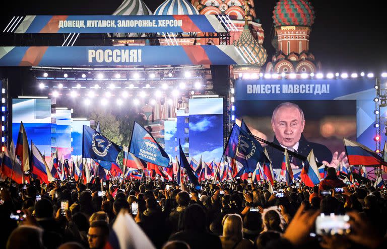 El público ondea banderas rusas durante el discurso de Putin en la Plaza Roja