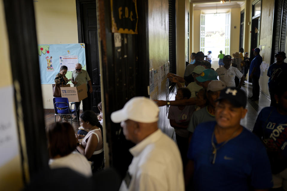 A man votes assisted by a woman during a general election in Panama City, Sunday, May 5, 2024. (AP Photo/Matias Delacroix)